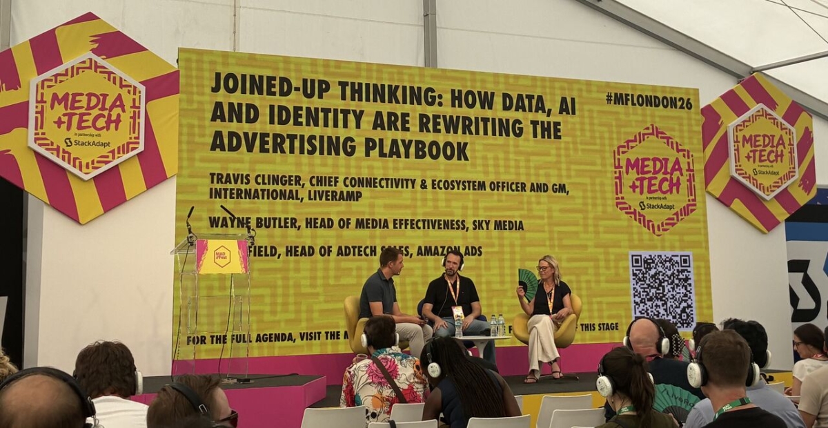 A panel of people on stage, accompanied by a banner that highlights the event or topic discussed: "Joined-up thinking: How data, AI and identity are rewriting the advertising playbook".
