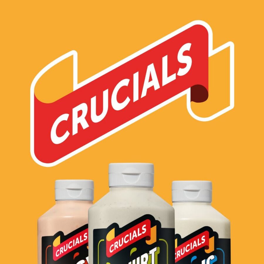 A bold red “Crucials” banner appears on an orange background above three bottles labeled spicy mayo, yoghurt mint, and garlic mayo. The design feels bright and playful.