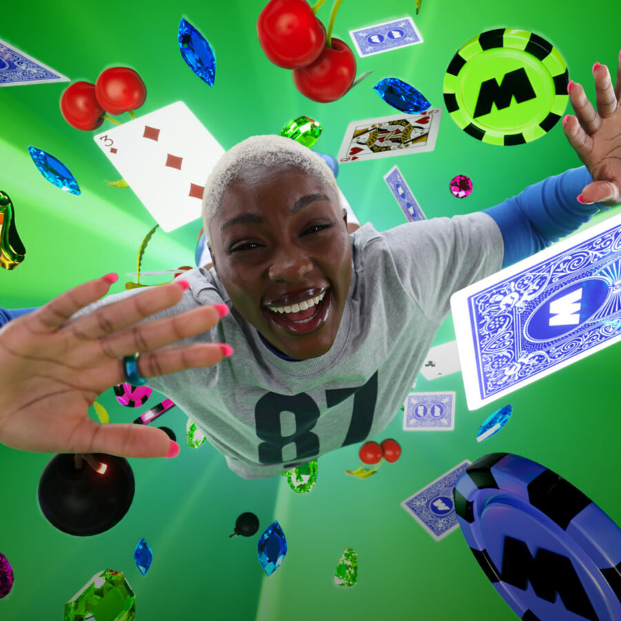 A joyful person reaches toward the camera amid floating playing cards, poker chips, dice, and colourful casino tokens on a vivid green background. This is a still from Midnite's Casino Done Better TV ad