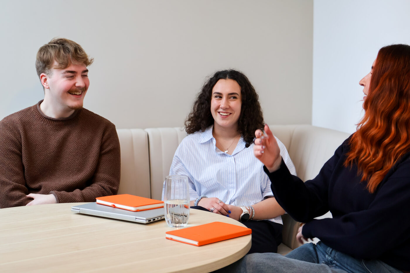 JAA team meet around table with orange note pads