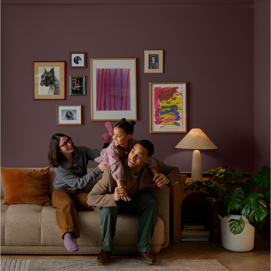 A couple is playing with there child on the sofa in the living room