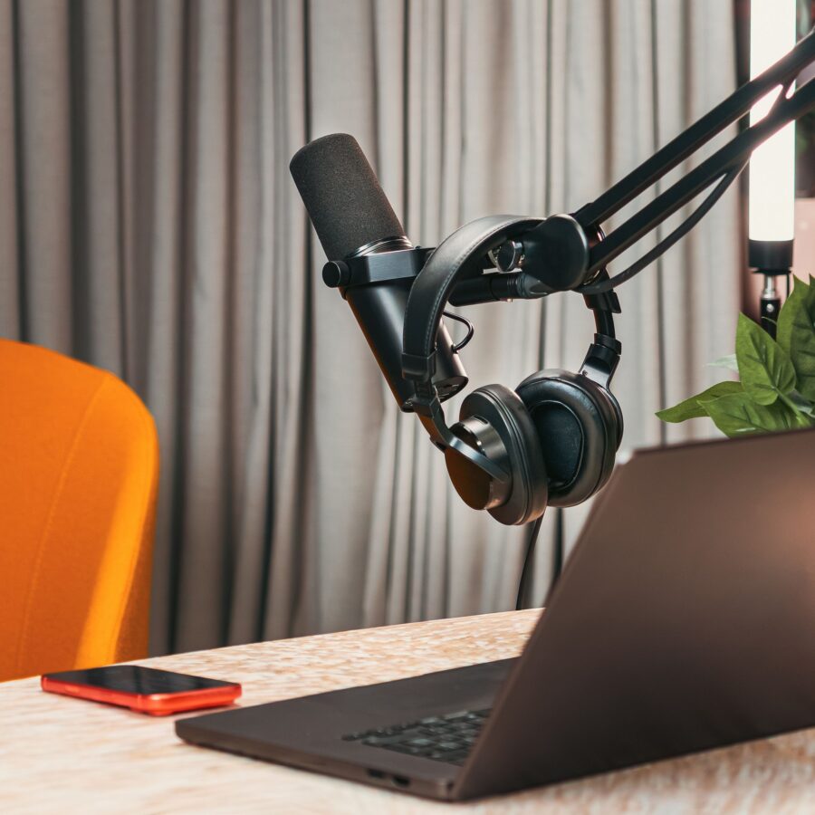 An orange chair is turned away from a podcast mixing desk